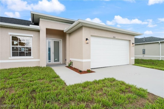 3109 11th St W, Lehigh Acres, FL 33971 - view of front facade with stucco siding, a garage, driveway, and french doors