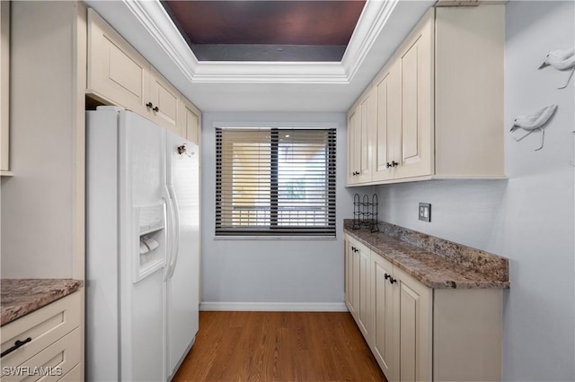 9820 Citadel Ln Unit 202, Bonita Springs, FL 34135 - kitchen featuring white fridge with ice dispenser, a tray ceiling, light wood-style flooring, and light stone counters