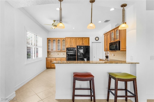 14813 Canton Ct, Naples, FL 34114 - kitchen with black appliances, a peninsula, crown molding, glass insert cabinets, and brown cabinets