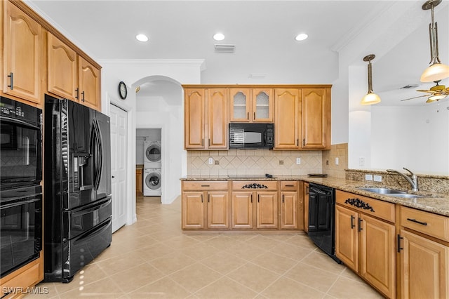 14813 Canton Ct, Naples, FL 34114 - kitchen featuring black appliances, stacked washing machine and dryer, light stone counters, crown molding, and a ceiling fan