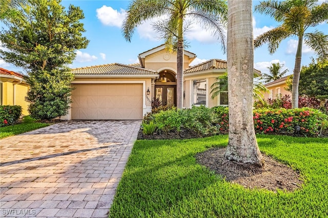 14813 Canton Ct, Naples, FL 34114 - mediterranean / spanish-style home with an attached garage, stucco siding, decorative driveway, a tiled roof, and french doors