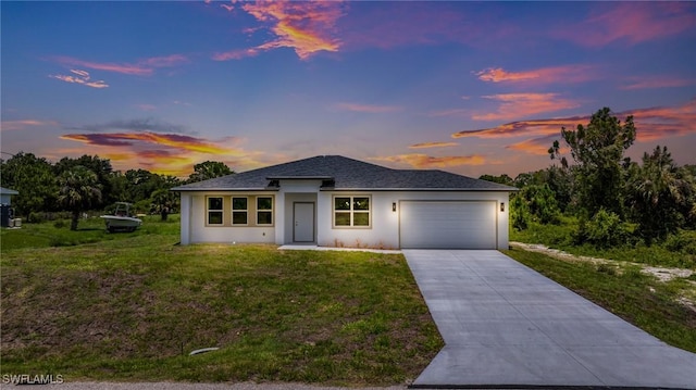 1909 Moore Ave, Lehigh Acres, FL 33972 - prairie-style home with an attached garage, driveway, a yard, and stucco siding