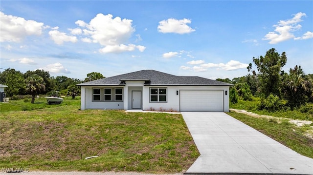 1909 Moore Ave, Lehigh Acres, FL 33972 - prairie-style house with a garage, driveway, a front lawn, stucco siding, and roof with shingles