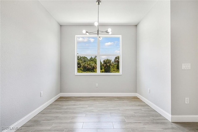 1909 Moore Ave, Lehigh Acres, FL 33972 - spare room with a chandelier and light wood-style flooring