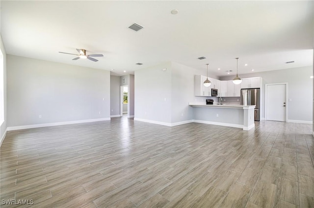 1909 Moore Ave, Lehigh Acres, FL 33972 - unfurnished living room with light wood-type flooring, ceiling fan, and recessed lighting