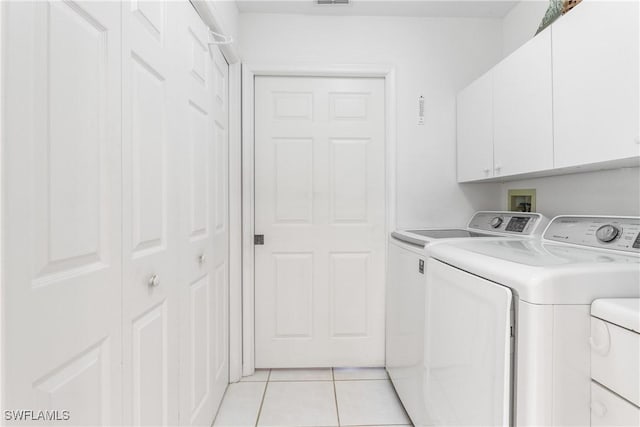 76 4th St Unit 2-102, Bonita Springs, FL 34134 - washroom featuring independent washer and dryer, cabinet space, and light tile patterned flooring