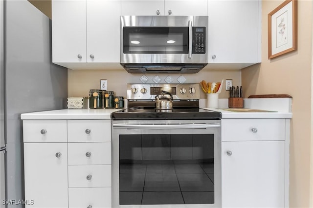 76 4th St Unit 2-102, Bonita Springs, FL 34134 - kitchen with stainless steel appliances, light countertops, and white cabinetry