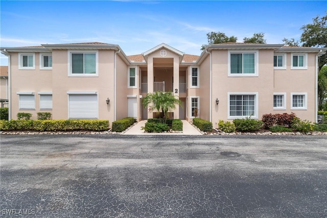 76 4th St Unit 2-102, Bonita Springs, FL 34134 - view of property with stucco siding and a balcony