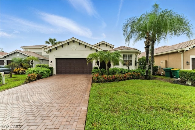 6899 Del Mar Ter, Naples, FL 34105 - mediterranean / spanish-style home with an attached garage, decorative driveway, a front yard, and stucco siding