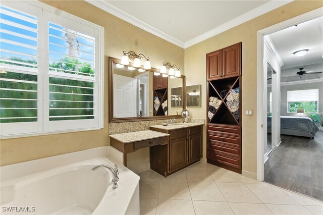 6899 Del Mar Ter, Naples, FL 34105 - ensuite bathroom featuring a bath, ornamental molding, vanity, a ceiling fan, and tile patterned floors
