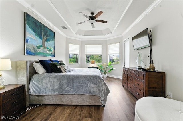 6899 Del Mar Ter, Naples, FL 34105 - bedroom featuring a tray ceiling, multiple windows, dark wood-style flooring, a ceiling fan, and ornamental molding