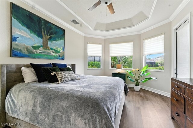 6899 Del Mar Ter, Naples, FL 34105 - bedroom with a raised ceiling, wood finished floors, crown molding, and ceiling fan