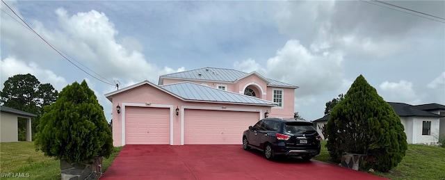 312 Lenz Ave S, Lehigh Acres, FL 33974 - traditional home featuring stucco siding, driveway, a garage, and a standing seam roof