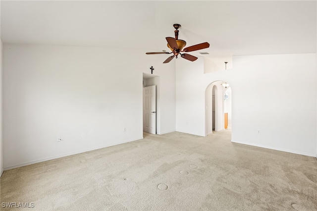 312 Lenz Ave S, Lehigh Acres, FL 33974 - empty room with arched walkways, a ceiling fan, light carpet, and vaulted ceiling