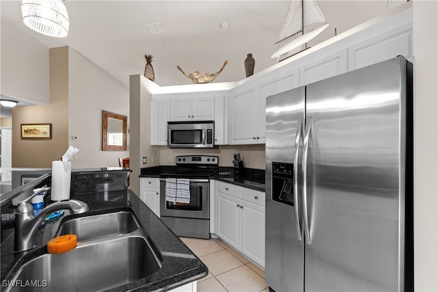 1057 Silverstrand Dr, Naples, FL 34110 - kitchen featuring stainless steel appliances, light tile patterned floors, white cabinets, decorative light fixtures, and dark stone countertops
