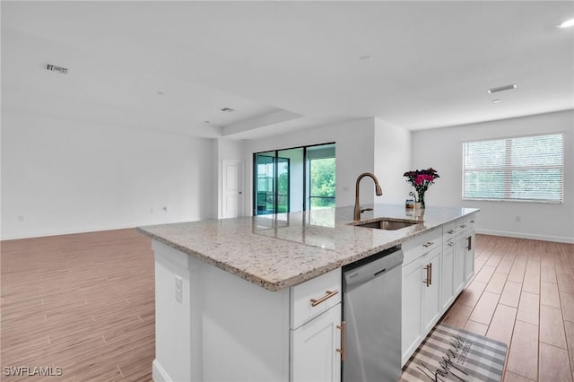 1801 Hagen Ct, Naples, FL 34120 - kitchen with stainless steel dishwasher, light wood-style flooring, an island with sink, open floor plan, and light stone counters