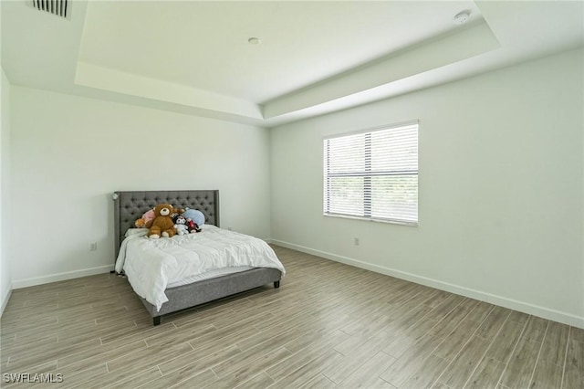 1801 Hagen Ct, Naples, FL 34120 - bedroom featuring a raised ceiling and light wood finished floors