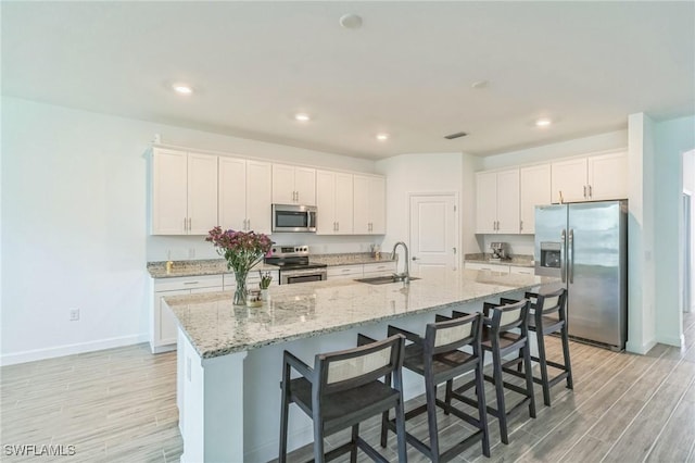 1801 Hagen Ct, Naples, FL 34120 - kitchen with stainless steel appliances, light wood finished floors, white cabinets, and recessed lighting