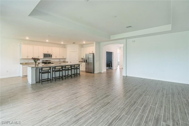 1801 Hagen Ct, Naples, FL 34120 - kitchen with stainless steel appliances, open floor plan, arched walkways, white cabinets, and recessed lighting