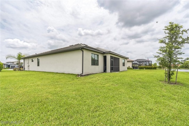 1801 Hagen Ct, Naples, FL 34120 - back of property with stucco siding, a lawn, a carport, and a lanai