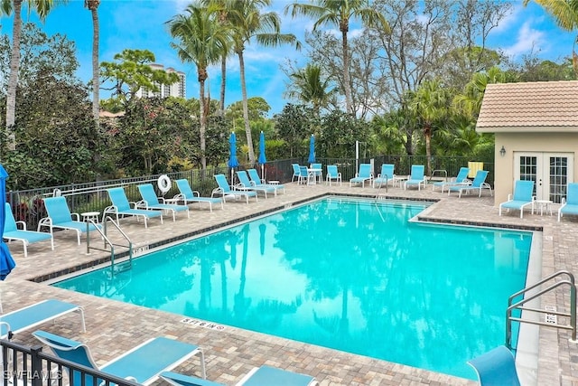 23751 Merano Ct Unit 201, Estero, FL 34134 - community pool with french doors, a patio, and view of scattered trees