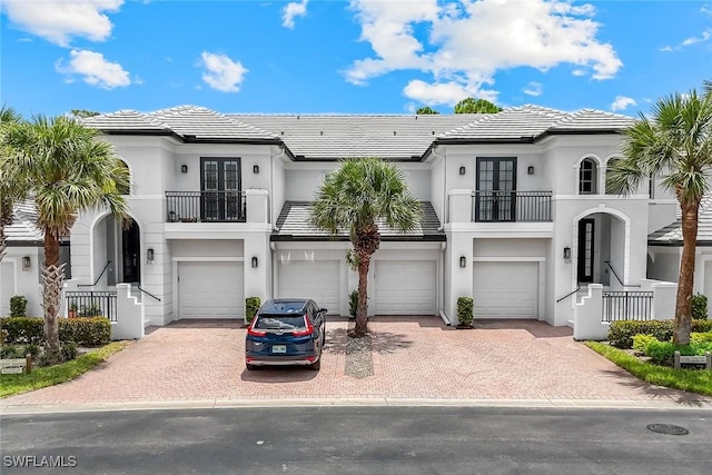23751 Merano Ct Unit 201, Estero, FL 34134 - view of front of property featuring a balcony, an attached garage, french doors, and driveway