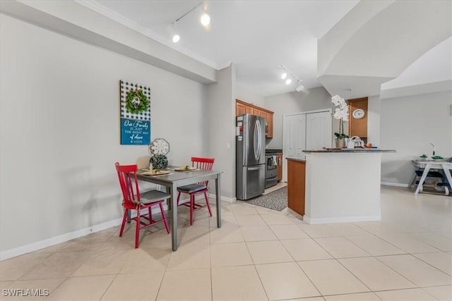 13010 Positano Cir Unit 206, Naples, FL 34105 - kitchen with rail lighting, appliances with stainless steel finishes, brown cabinets, a peninsula, and ornamental molding