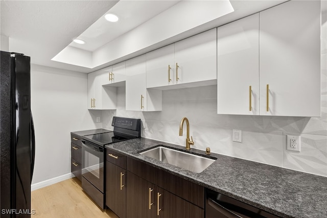 610 SW 47th Ter Unit 2, Cape Coral, FL 33914 - kitchen featuring black appliances, white cabinets, tasteful backsplash, dark stone counters, and light wood-type flooring