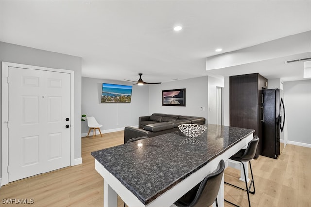 610 SW 47th Ter Unit 2, Cape Coral, FL 33914 - kitchen with freestanding refrigerator, light wood-style flooring, a kitchen breakfast bar, ceiling fan, and a kitchen island