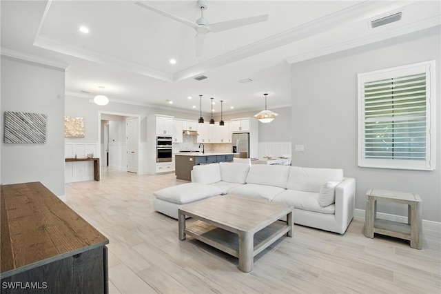 8951 Saint Lucia Dr, Naples, FL 34114 - living room with a raised ceiling, ornamental molding, recessed lighting, ceiling fan, and light wood-style floors