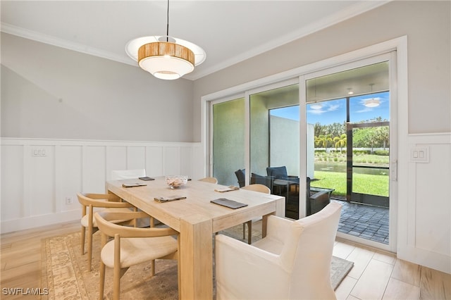 8951 Saint Lucia Dr, Naples, FL 34114 - dining room featuring ornamental molding, a decorative wall, wainscoting, and light wood-type flooring