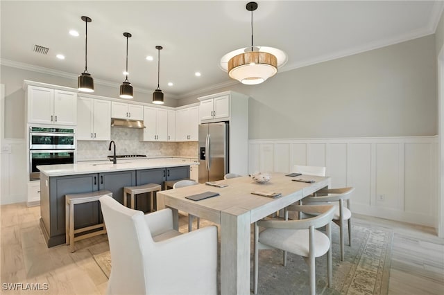 8951 Saint Lucia Dr, Naples, FL 34114 - dining space featuring ornamental molding, a wainscoted wall, a decorative wall, and recessed lighting