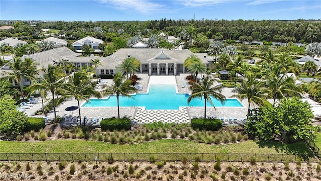 8951 Saint Lucia Dr, Naples, FL 34114 - community pool with a patio area and view of wooded area