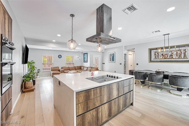 675 Logan Blvd S, Naples, FL 34119 - kitchen featuring island range hood, black electric stovetop, recessed lighting, light wood finished floors, and modern cabinets