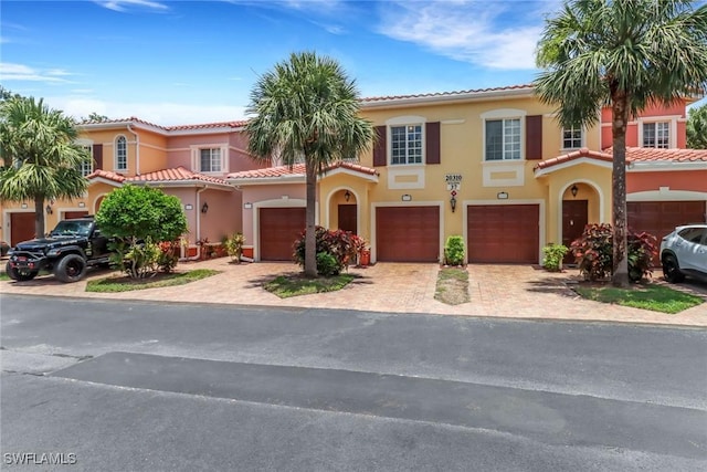 20310 Estero Gardens Cir Unit 203, Estero, FL 33928 - mediterranean / spanish-style house featuring a tile roof, stucco siding, driveway, and an attached garage