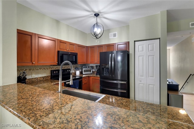 20310 Estero Gardens Cir Unit 203, Estero, FL 33928 - kitchen with black appliances, backsplash, decorative light fixtures, a peninsula, and dark stone counters