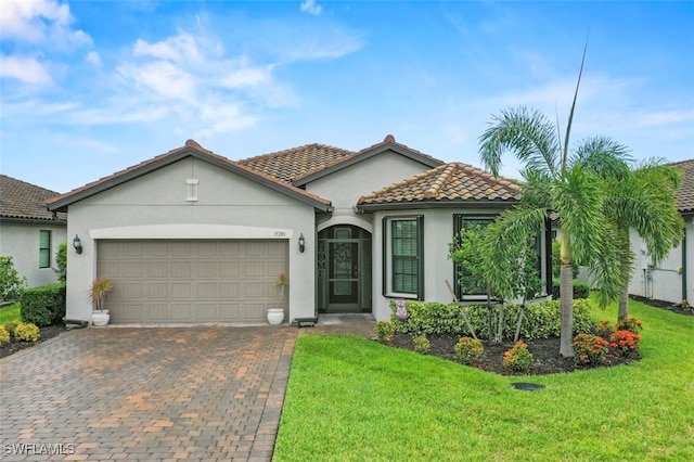 19280 Elston Way, Estero, FL 33928 - mediterranean / spanish home with stucco siding, decorative driveway, a garage, a front lawn, and a tiled roof
