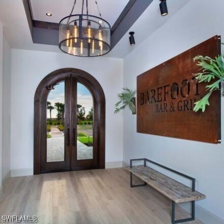 19280 Elston Way, Estero, FL 33928 - entryway with arched walkways, a chandelier, and wood finished floors