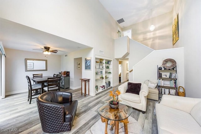 402 Bristle Cone Ln Unit 2, Naples, FL 34113 - living area with light wood finished floors, built in shelves, a high ceiling, ceiling fan, and stairway