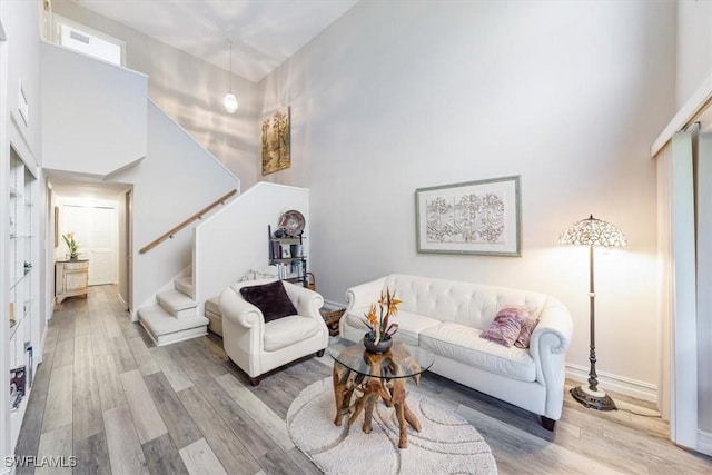 402 Bristle Cone Ln Unit 2, Naples, FL 34113 - living room featuring a towering ceiling, stairs, and wood finished floors