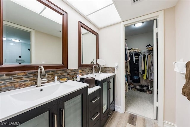 402 Bristle Cone Ln Unit 2, Naples, FL 34113 - full bath featuring vanity, wood finished floors, a walk in closet, and backsplash