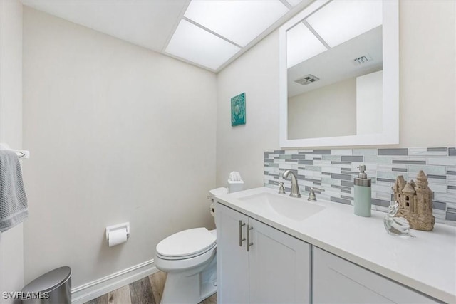 402 Bristle Cone Ln Unit 2, Naples, FL 34113 - half bathroom with wood finished floors, decorative backsplash, and vanity