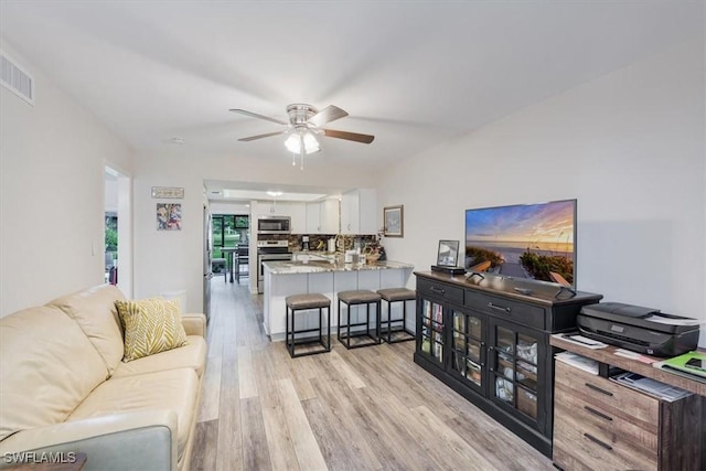 402 Bristle Cone Ln Unit 2, Naples, FL 34113 - living room with light wood-style floors and a ceiling fan