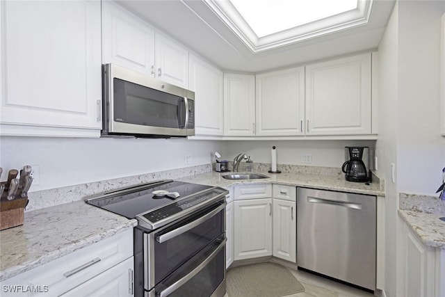180 Seaview Ct Unit 215, Marco Island, FL 34145 - kitchen with appliances with stainless steel finishes, white cabinetry, and light stone countertops
