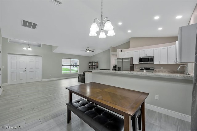 1417 Acacia Ave, Lehigh Acres, FL 33972 - kitchen featuring stainless steel appliances, a chandelier, white cabinets, decorative light fixtures, and lofted ceiling