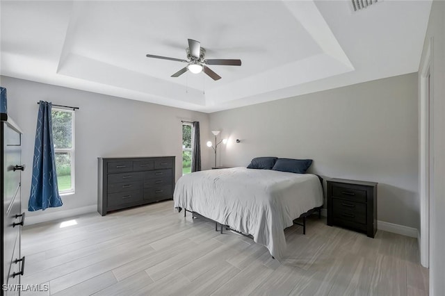 1417 Acacia Ave, Lehigh Acres, FL 33972 - bedroom with a tray ceiling, light wood-style flooring, and a ceiling fan