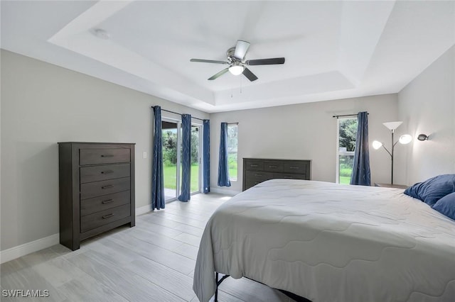 1417 Acacia Ave, Lehigh Acres, FL 33972 - bedroom featuring a tray ceiling, access to outside, multiple windows, and a ceiling fan
