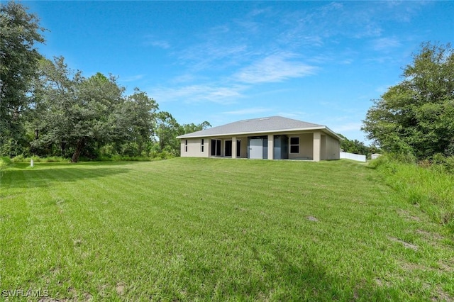 1417 Acacia Ave, Lehigh Acres, FL 33972 - rear view of property with a yard