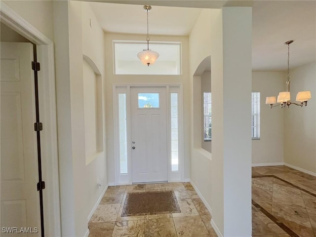 812 Grand Rapids Blvd, Naples, FL 34120 - entryway with arched walkways, a chandelier, and stone finish floors