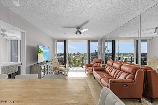 180 Seaview Ct Unit 612, Marco Island, FL 34145 - living room featuring ceiling fan, wood finished floors, a wall of windows, a textured ceiling, and healthy amount of natural light